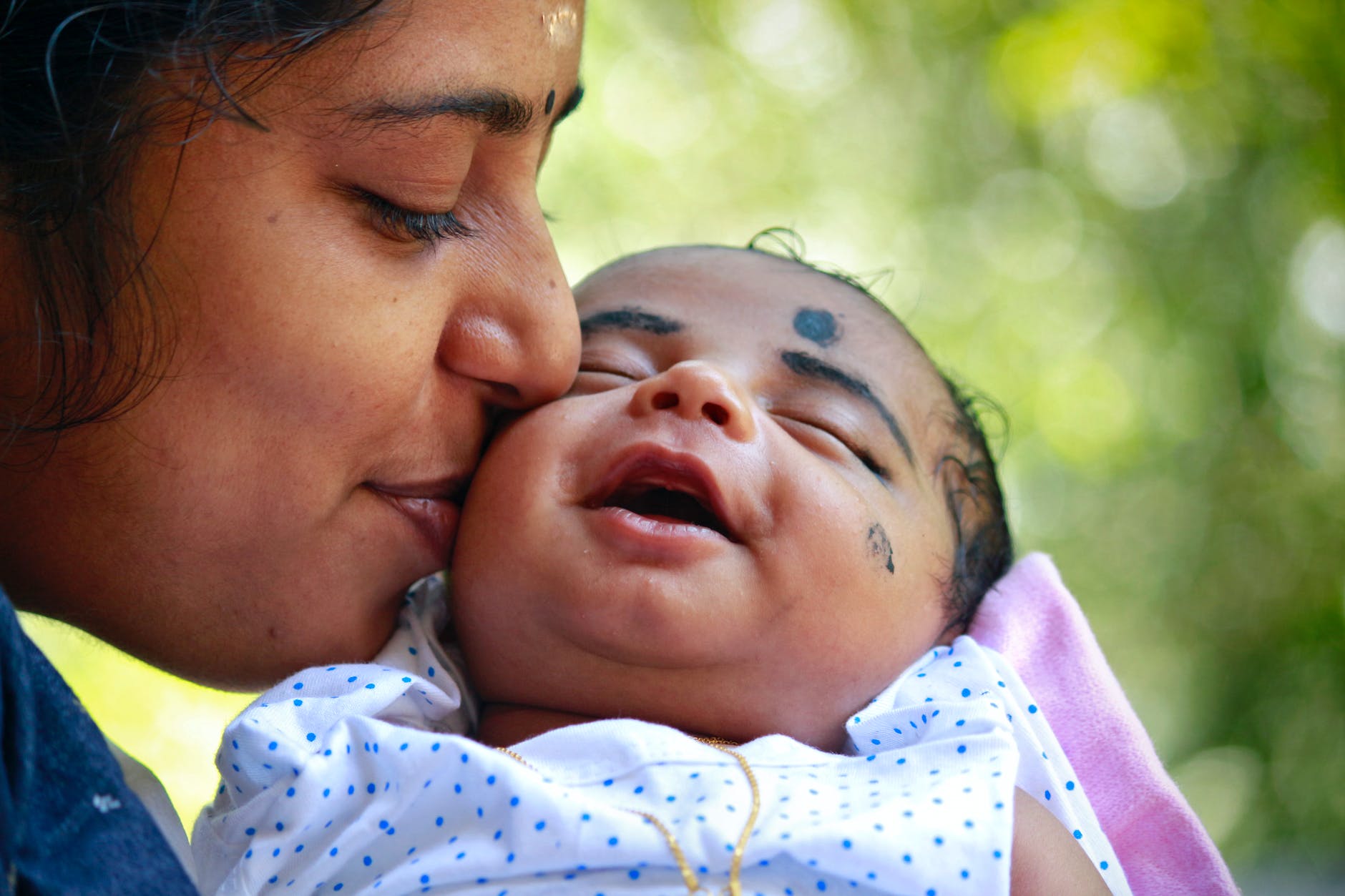 mother kissing child on cheek