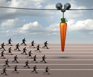 people chasing carrot on stick