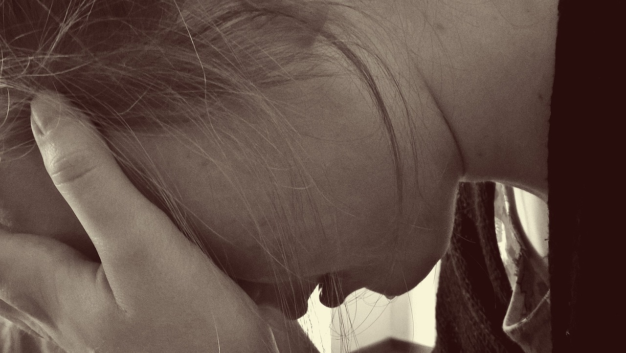 grieving woman head in hands