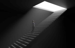 woman walking up stairs from dark into light